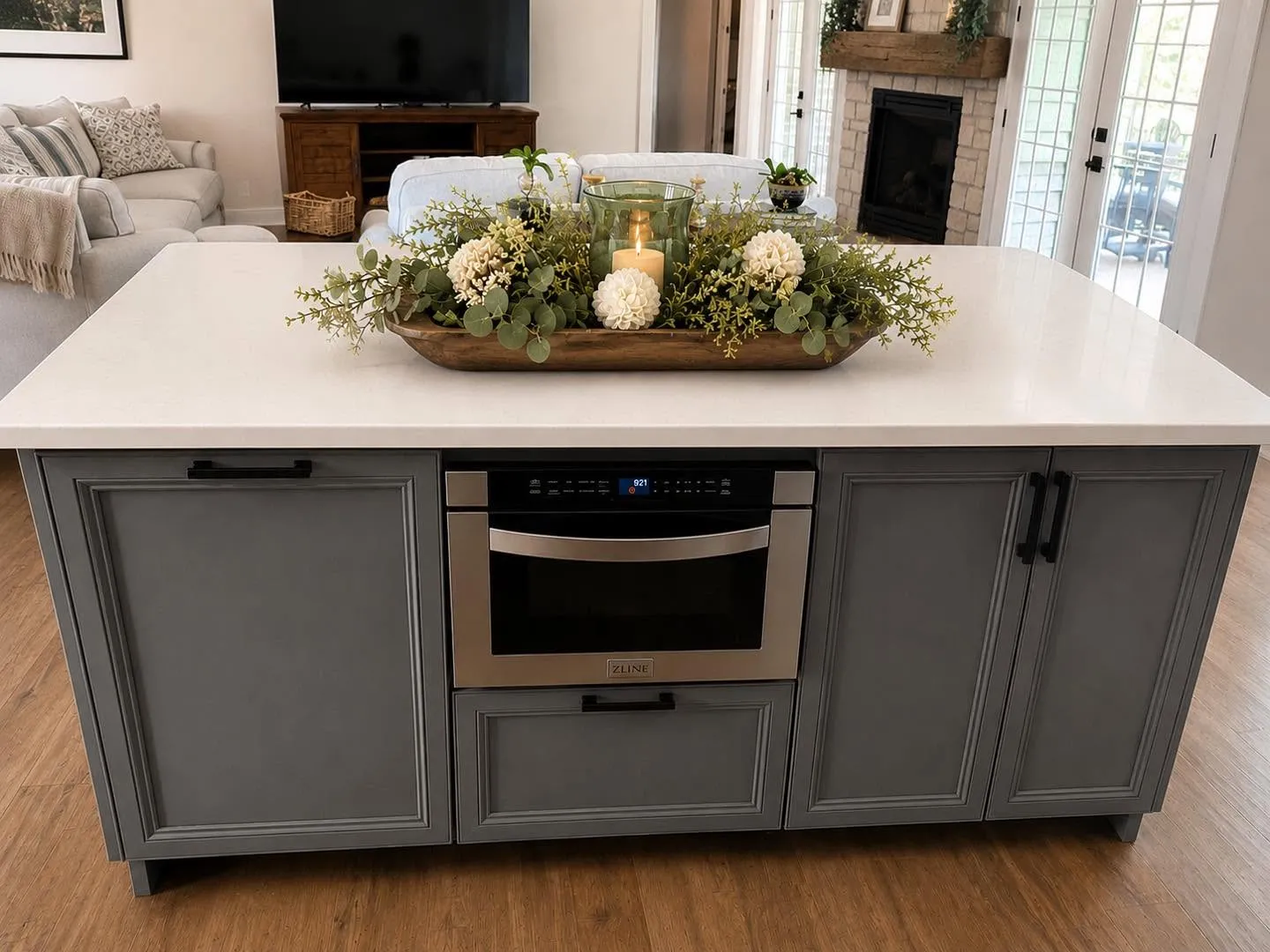 Custom color island with built-in microwave drawer, paired with custom stained oak cabinetry