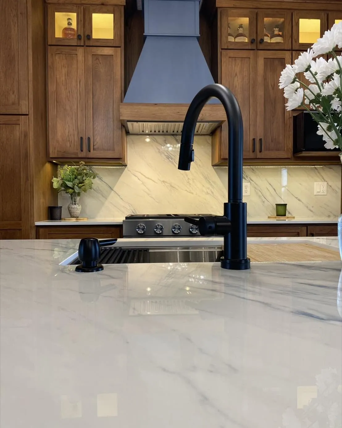 Matte black faucet detail against marble waterfall island