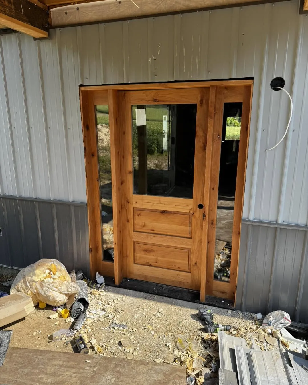 Knotty pine entry door with sidelights installed on a metal building