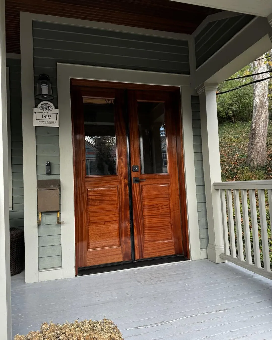 Custom mahogany double entry doors with glass lites on a covered front porch