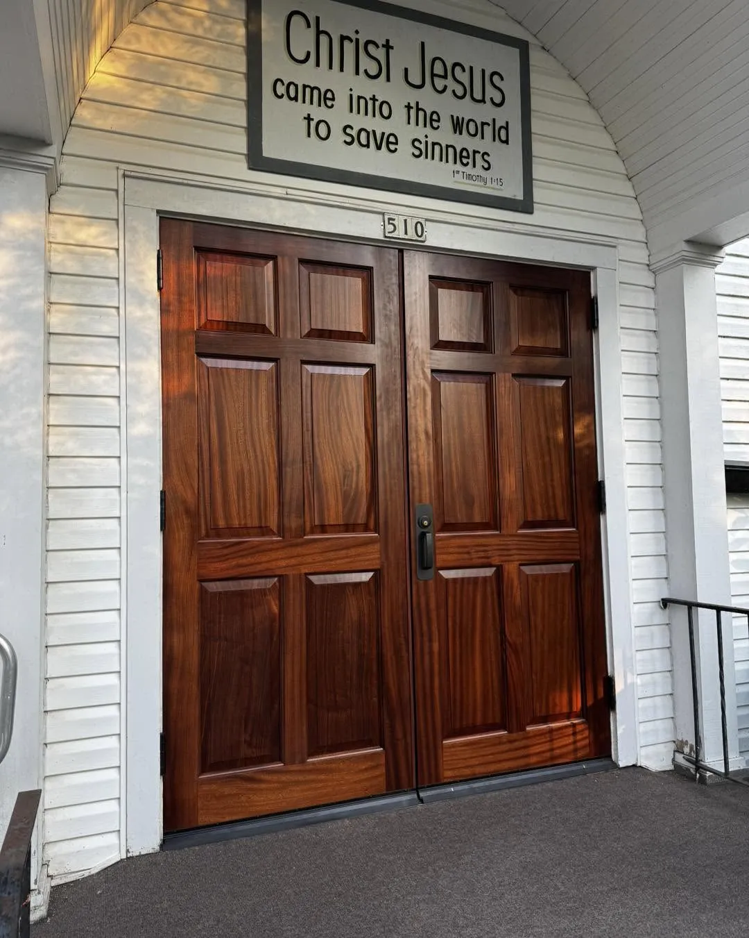 Mahogany raised-panel double entry doors installed on a church facade