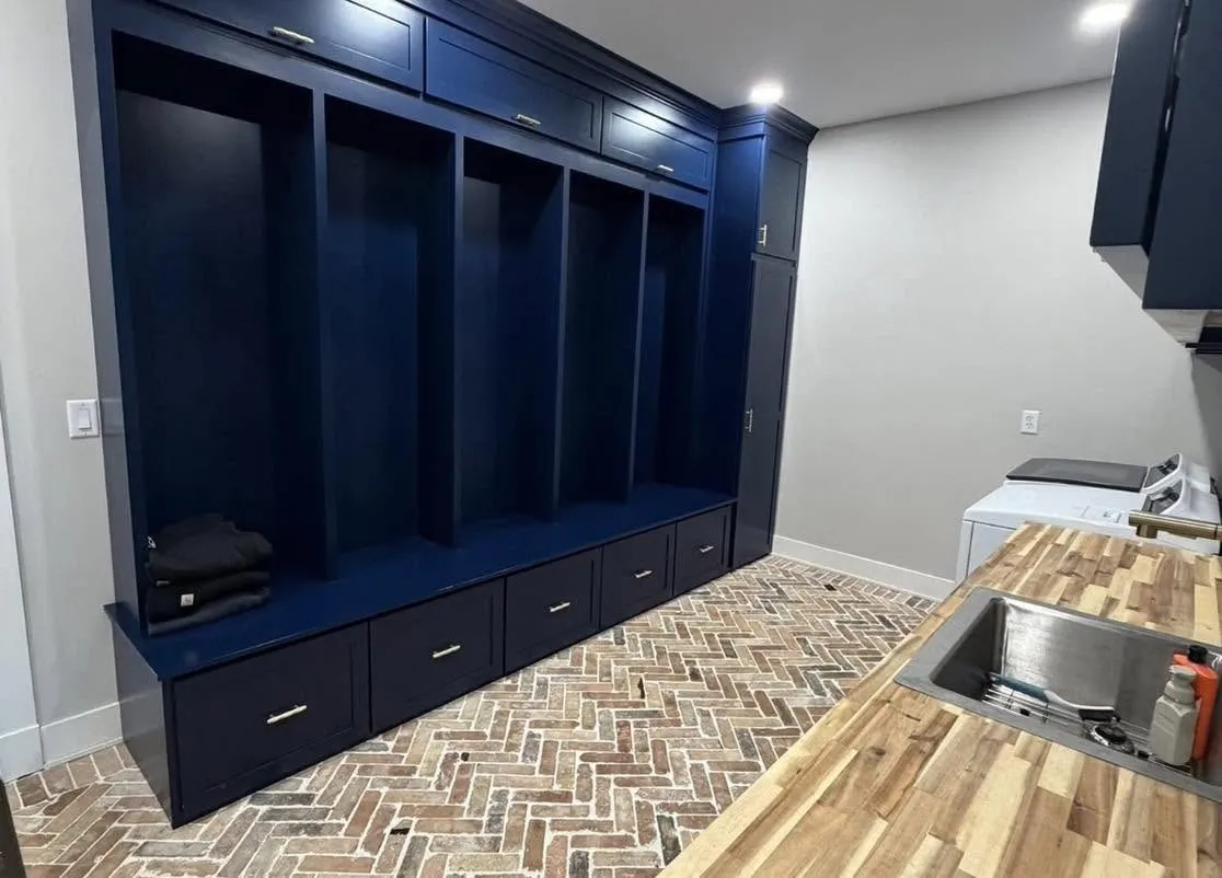 Navy blue mudroom locker unit with five cubbies and drawer storage