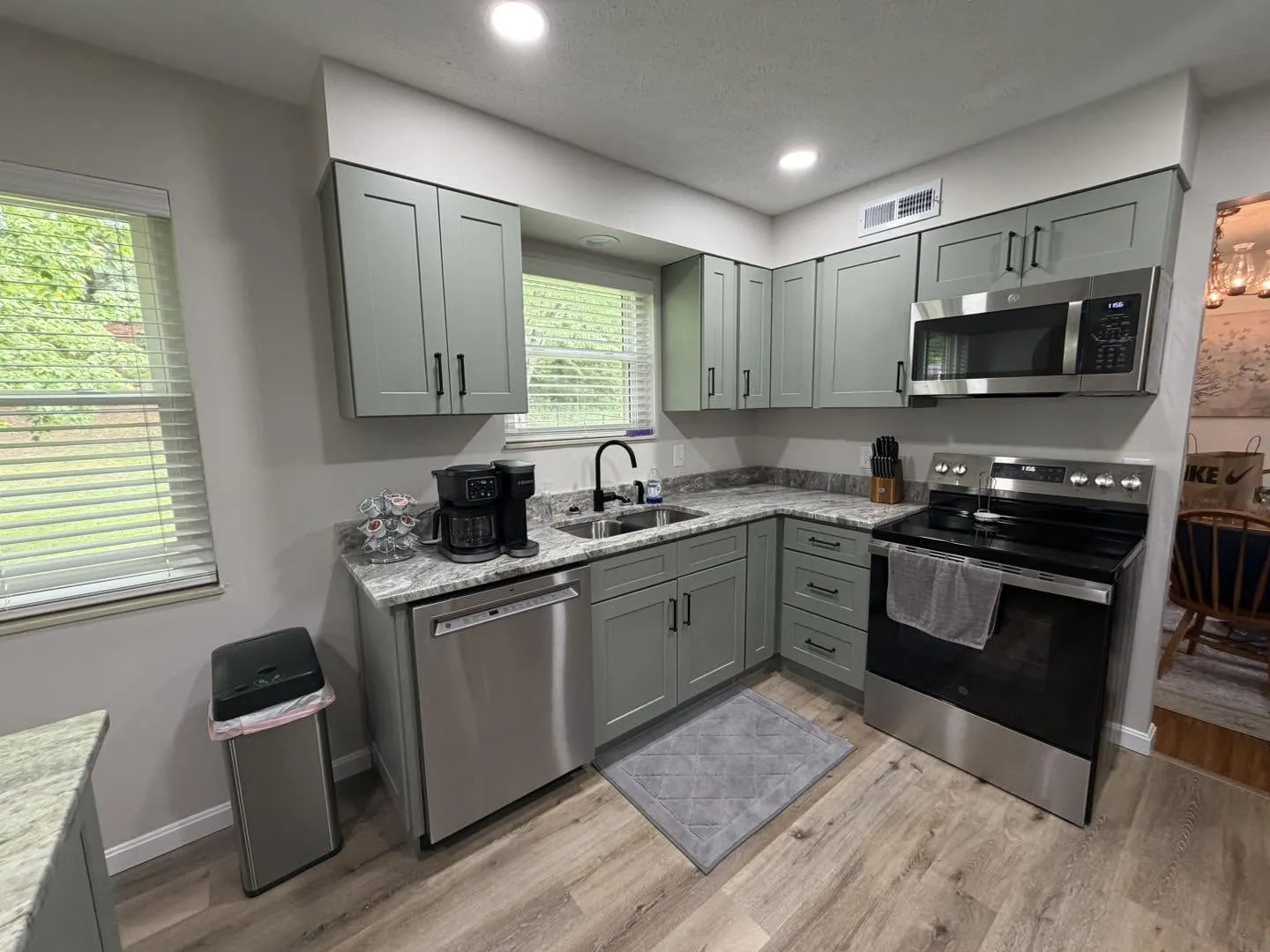 Sage green custom cabinetry kitchen with stainless appliances