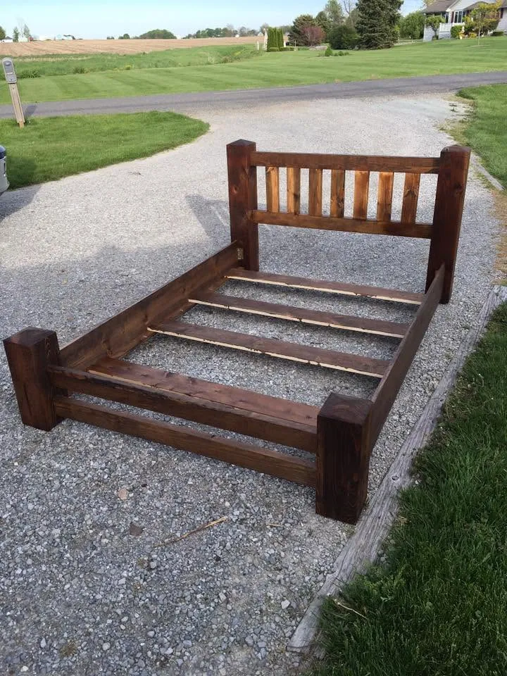 Slatted wood bed frame with post headboard, staged before delivery