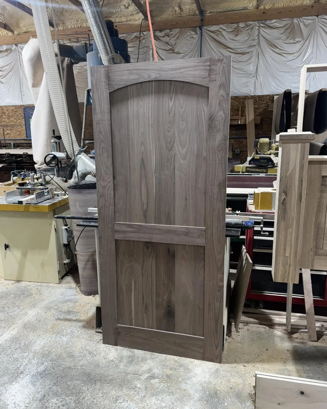 Solid walnut interior door with an arched panel insert