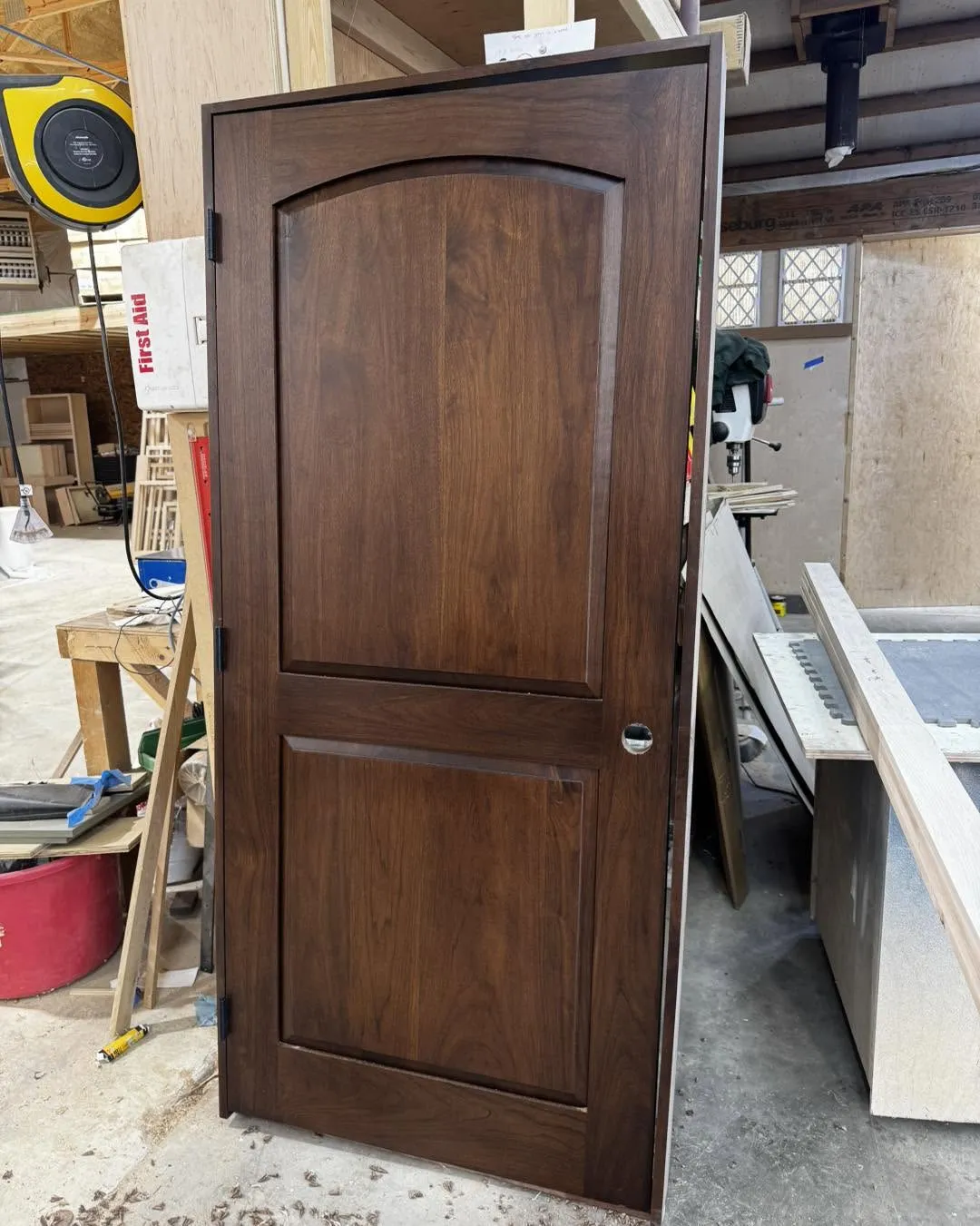 Solid walnut interior door with an arched panel insert, installed and hung