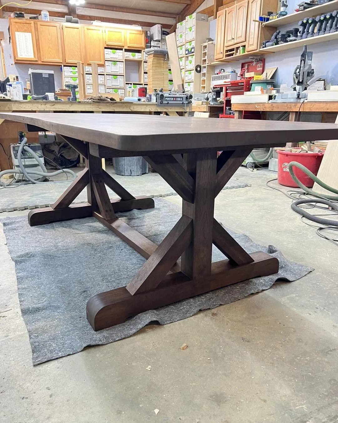 Solid walnut trestle dining table with a cross-buck base