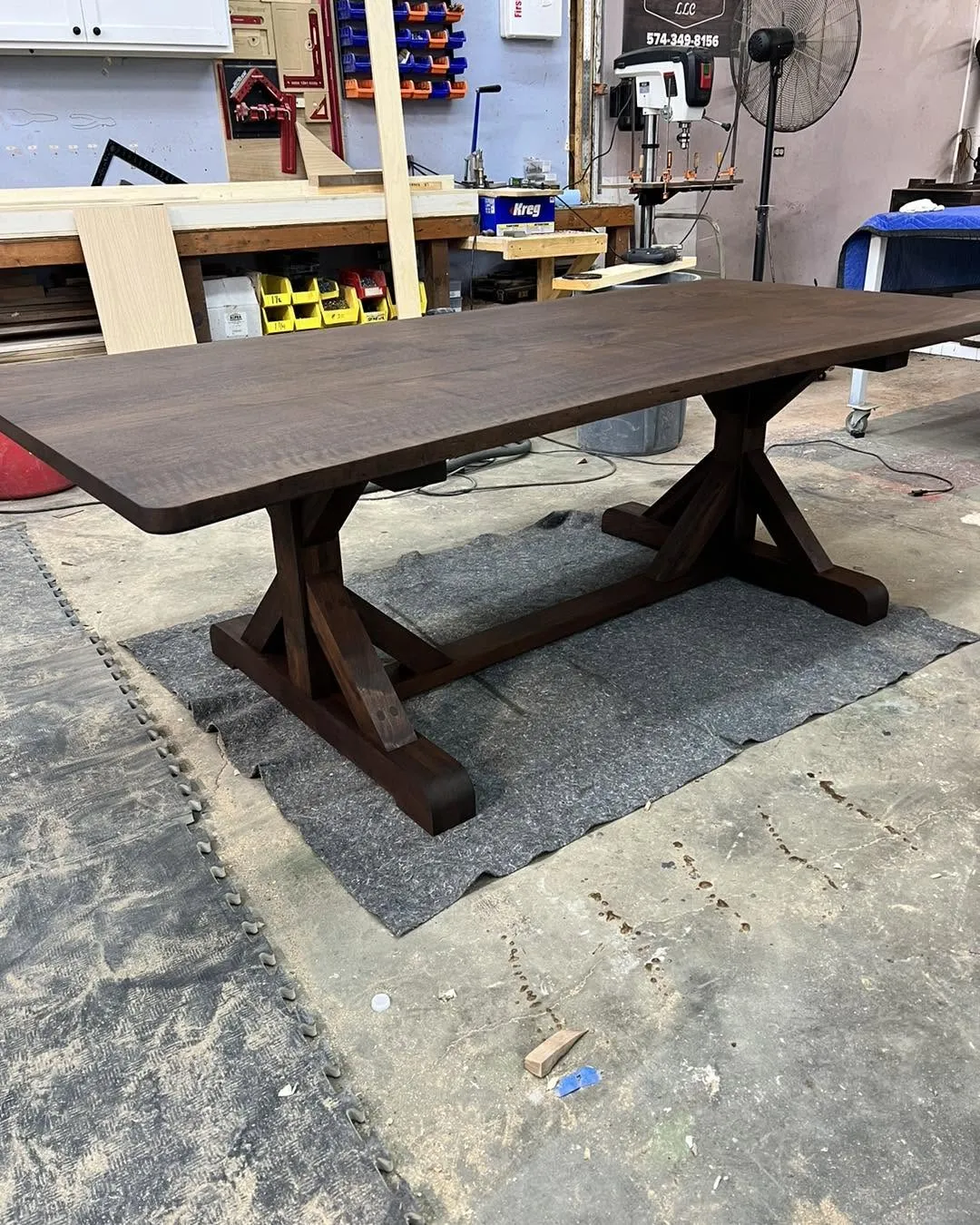 Dark walnut trestle dining table with a cross-buck base