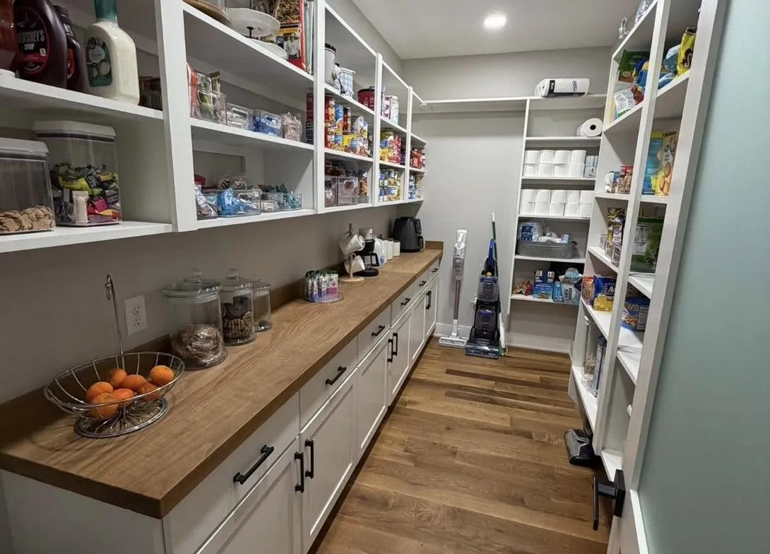 Built-in white pantry shelving and cabinetry with a butcher block counter
