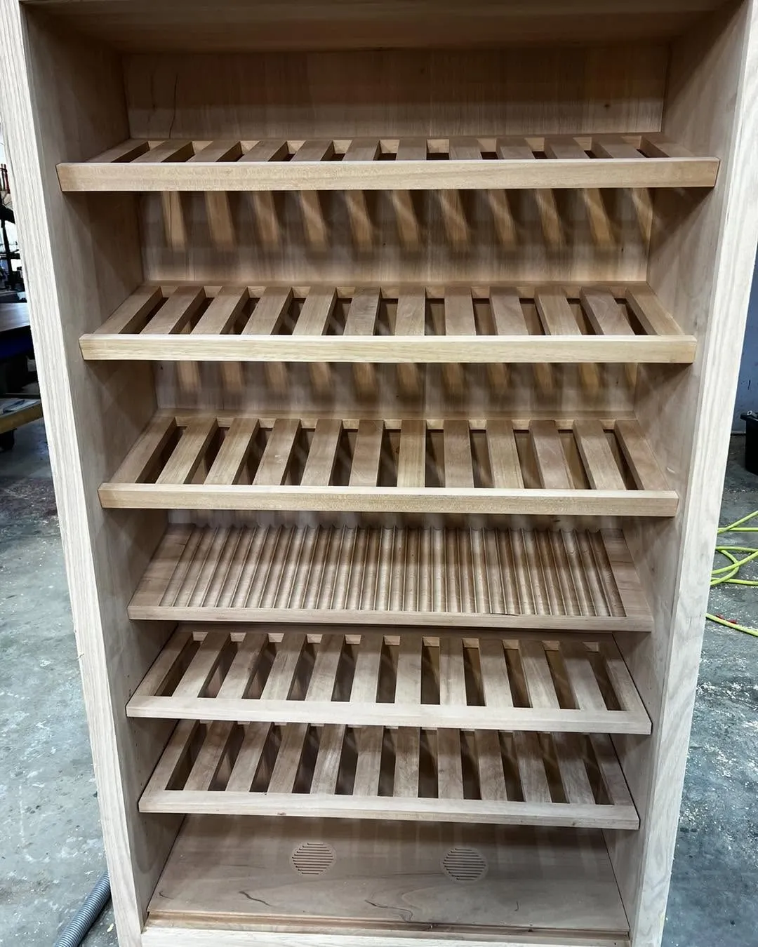 Custom built-in wine cabinet with slatted bottle storage shelving